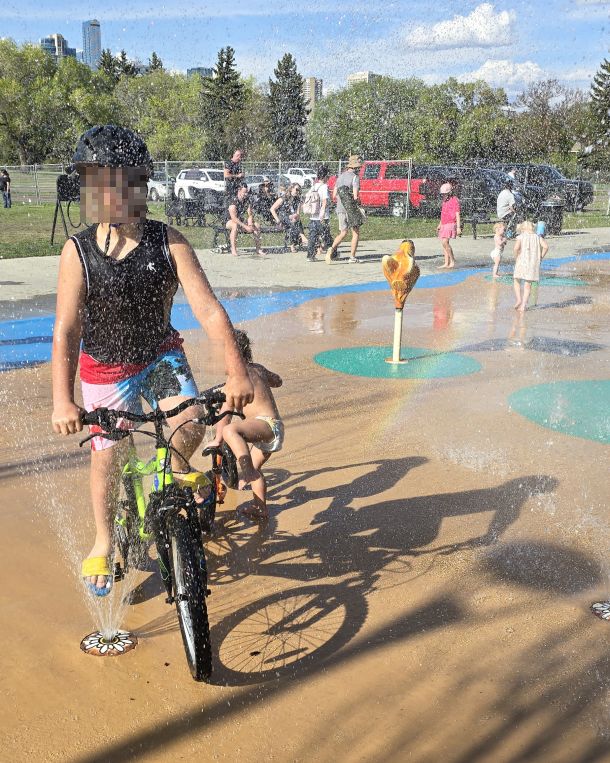 The current 9-year old at the spray park, rolling through the streams.