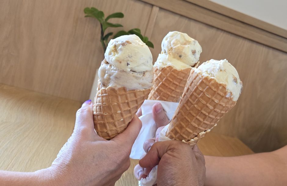 3 waffle cones of ice cream of varying flavours held by varying flavours of human.